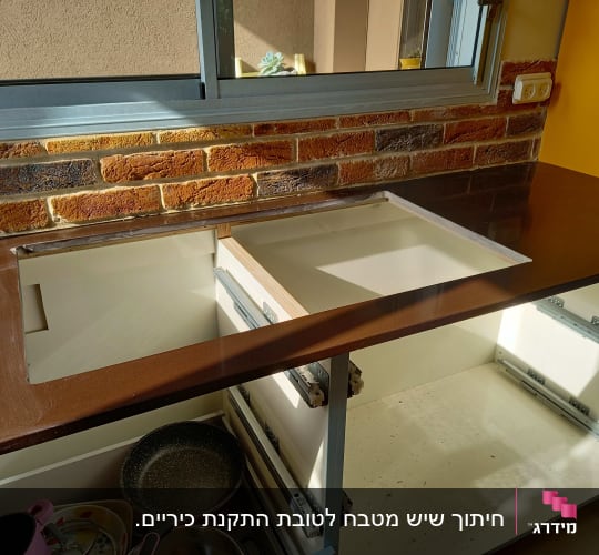 משטח שיש חום עם חיתוך לכיור במטבח